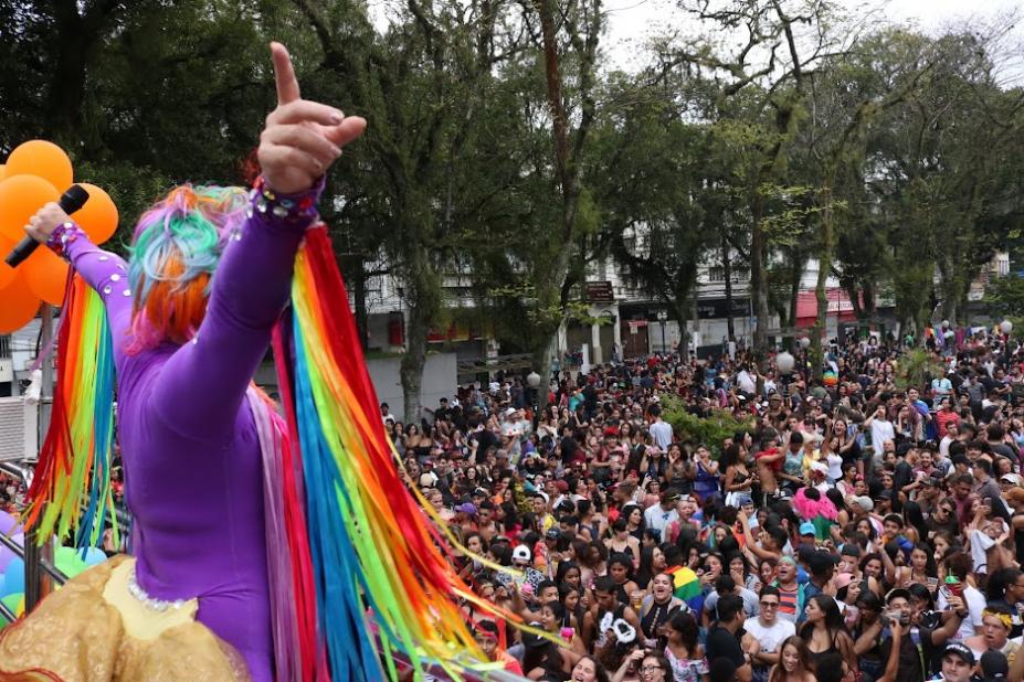 DRAG QUEEN DE COSTAS PARA A FOTO E DIANTE DE GRANDE PÚBLICO EM PRAÇA. #PARATODOSVEREM