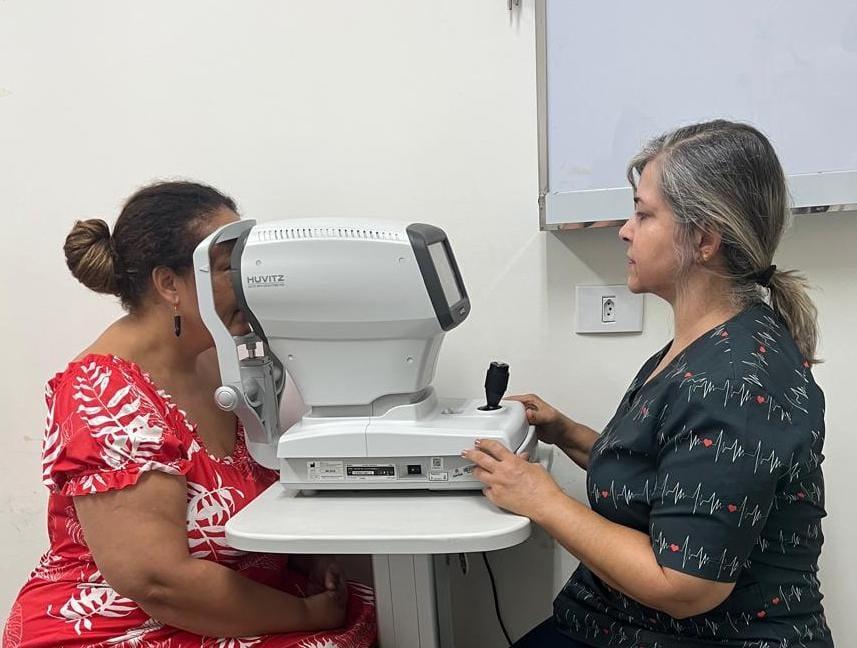 mulher é examida por outra com uso de equipamento. #paratodosverem