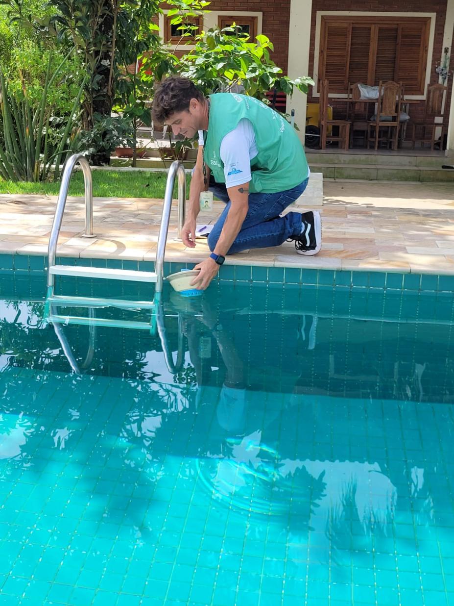 agente recolhe água de piscina. #paratodosverem 