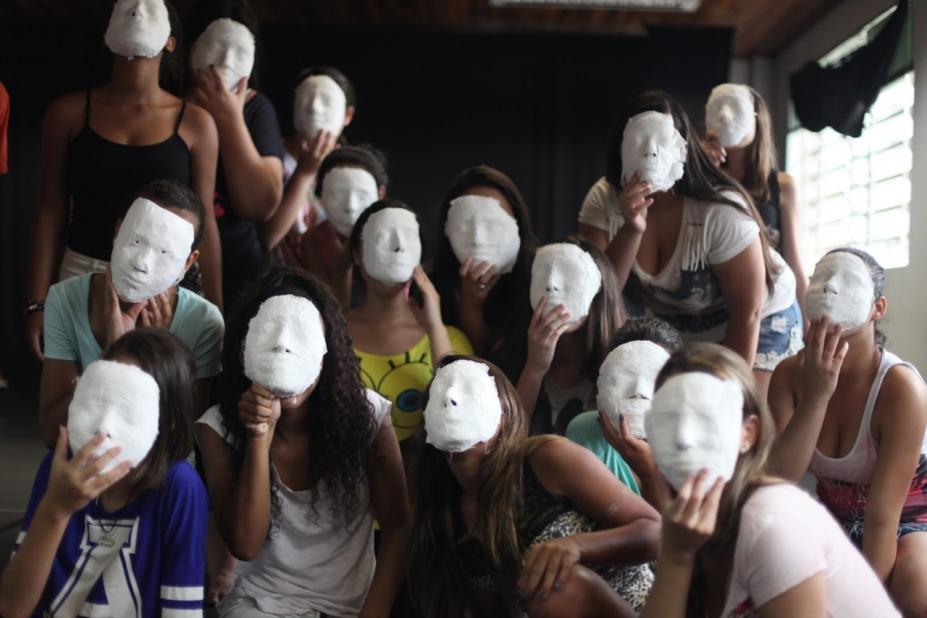 Várias pessoas estão cobrindo o rosto com uma máscara branca. #paratodosverem