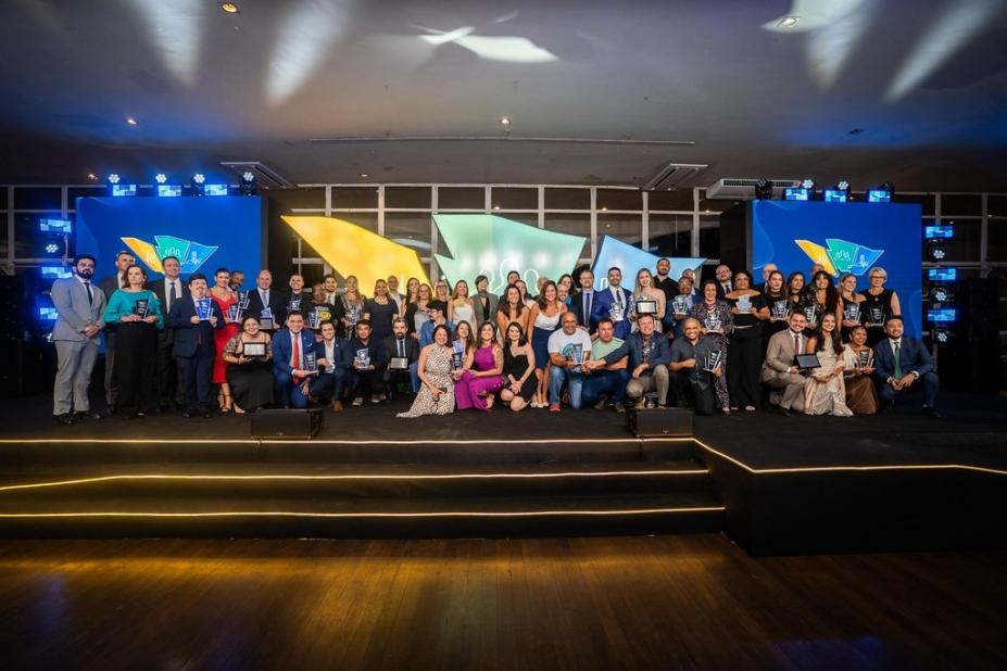 premiados posam para foto em palco. #paratodosverem