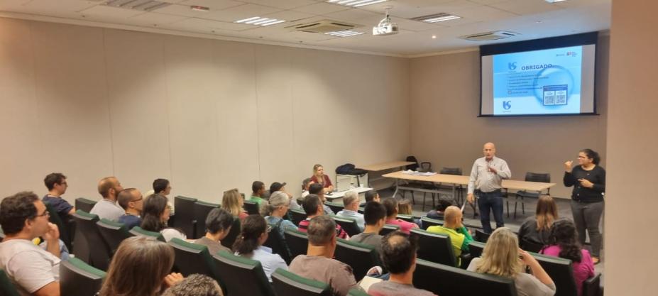 servidores estão sentados em auditório assistindo palestra. #paratodosverem