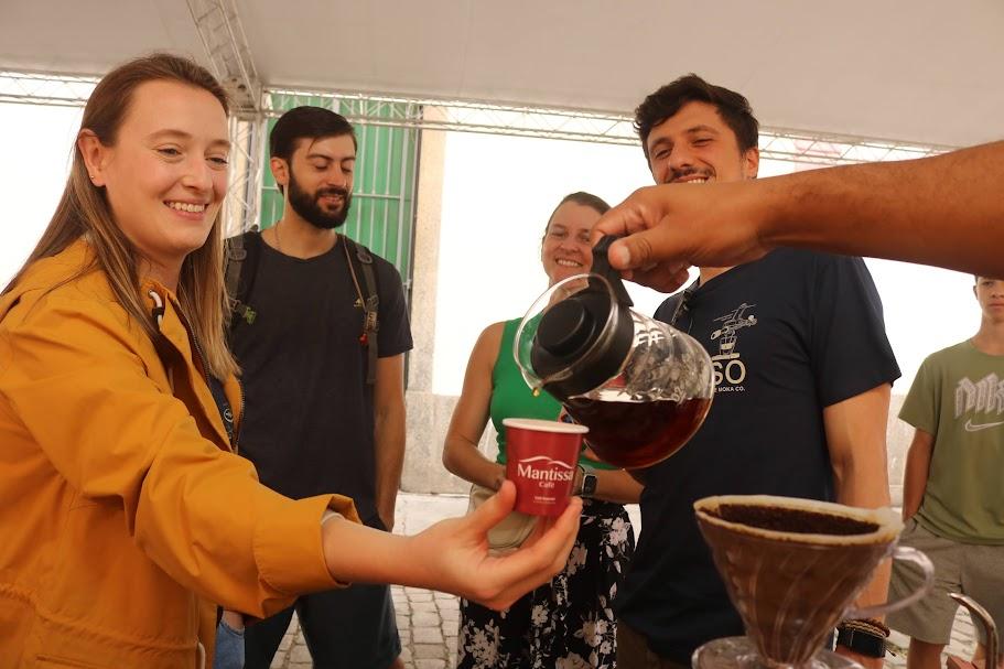 mão serve café para mulher em estande. #paratodosverem