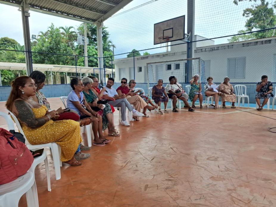 pessoas sentadas para reunião em quadra esportiva. #paratodosverem