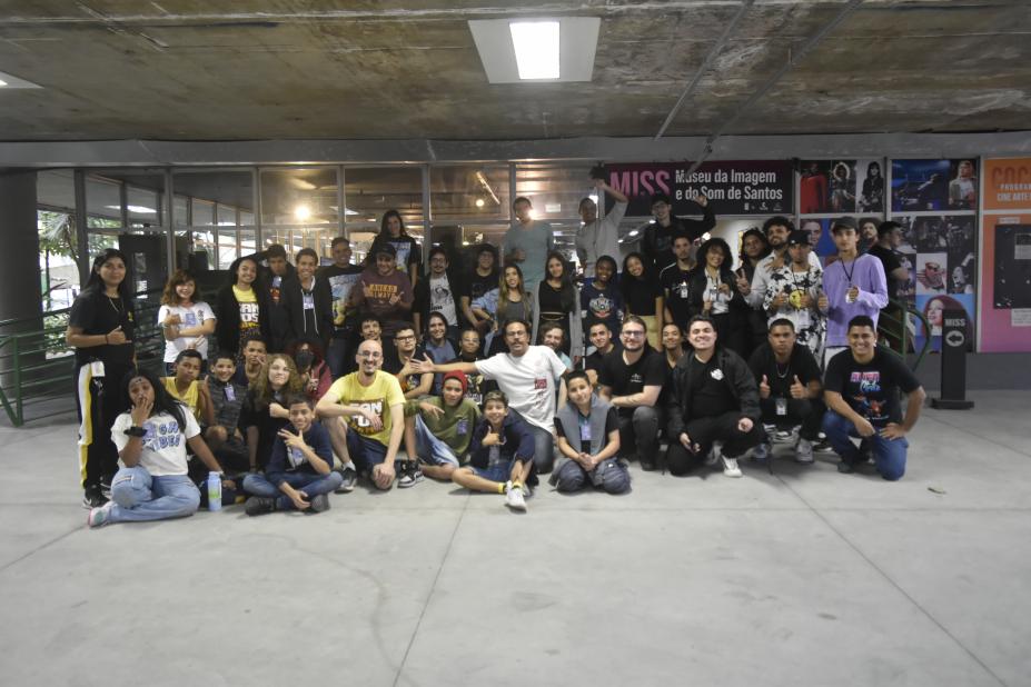 Jovens reunidos posam para foto em saguão. #paratodosverem