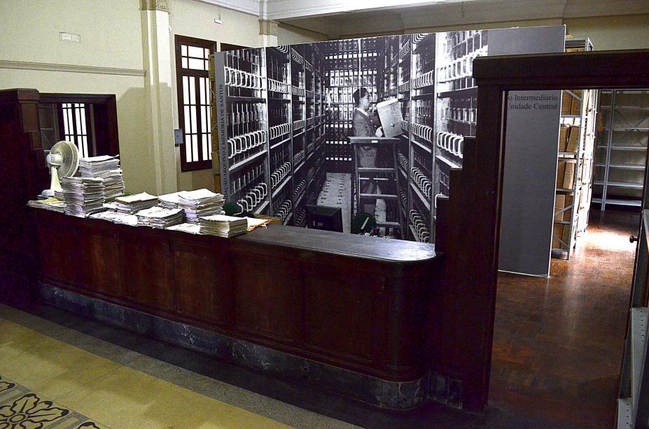 interior de prédio com documentos sobre um móvel antigo. #paratodosverem 