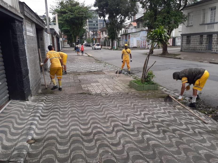 três homens estão capinando meio-fio e calçada. #paratodosverem