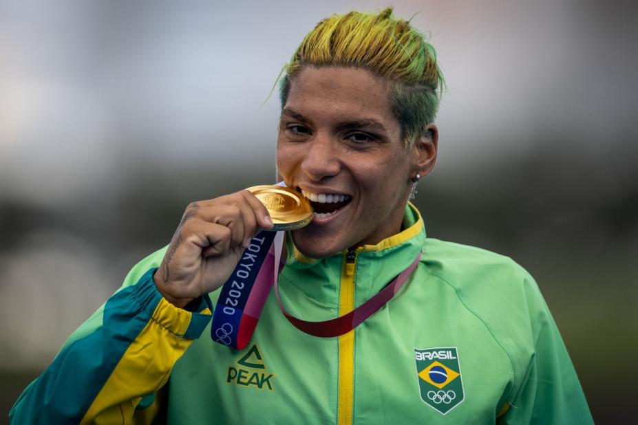 Atleta com agasalho do Brasil morde medalha de ouro #paratodosverem