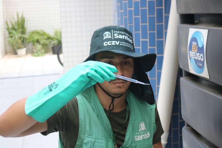 agente analisa tubo com larvas #paratodosverem