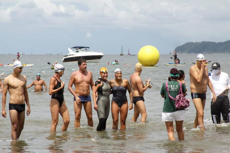 A campeã olímpica tira fotos com participantes da prova já na saída da água. #pracegover