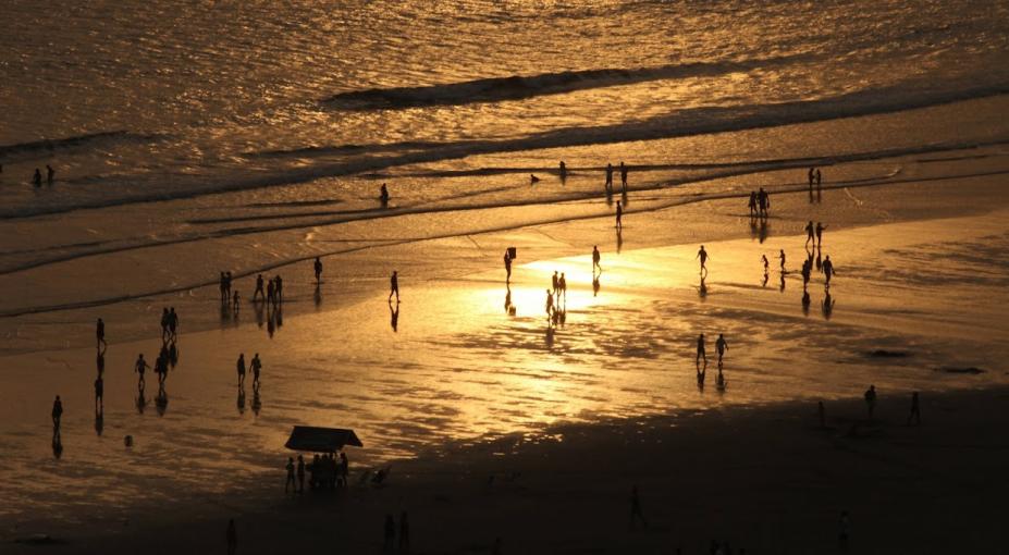 pessoas andando na beira da agua na praia #paratodosverem