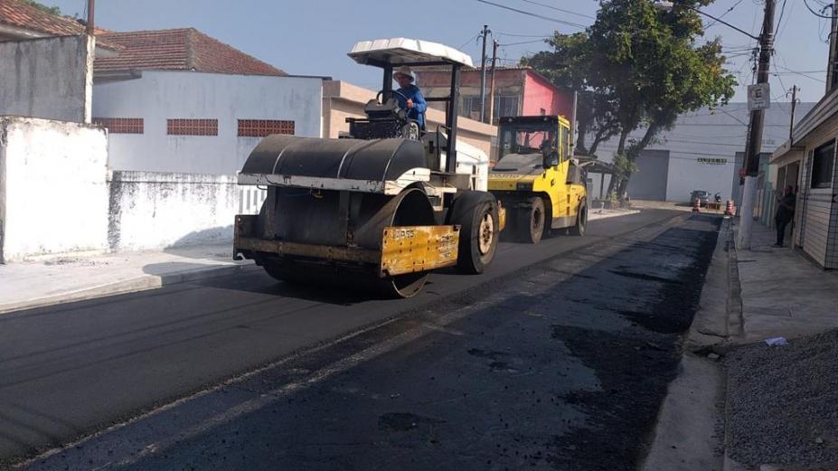 máquina compactadora passa sobre asfalto em rua. #paratodosverem 