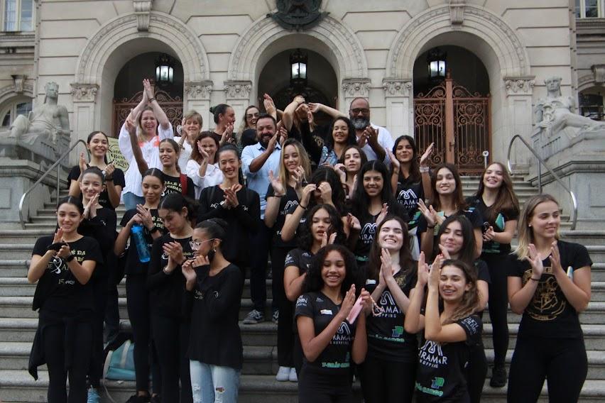 Bailarinas posam para foto na escadaria da frente da prefeitura. Elas batem palmas. #paratodosverem