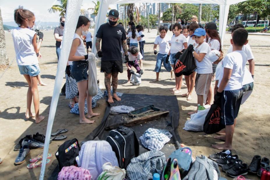 ALUNOS SE REÚNEM SOB TENDA PARA DESPEJAS RESÍDUOS COLETADOS. #PARATODOSVEREM