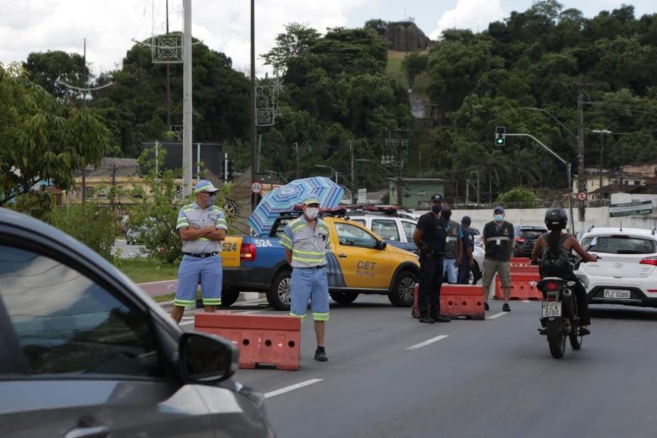 Agentes de tráfego e fiscais observam fluxo de veículos. #pracegover