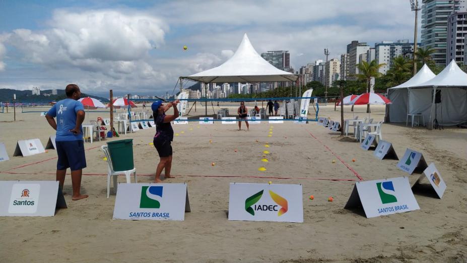 Estrutura com quadra do esporte na praia e pessoa praticando #paratodosverem