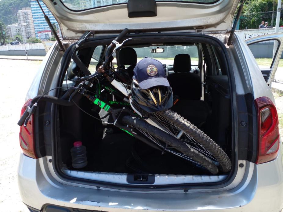 duas bikes no bagageiro de viatura que está com a porta do porta-malas aberta. #paratodosverem