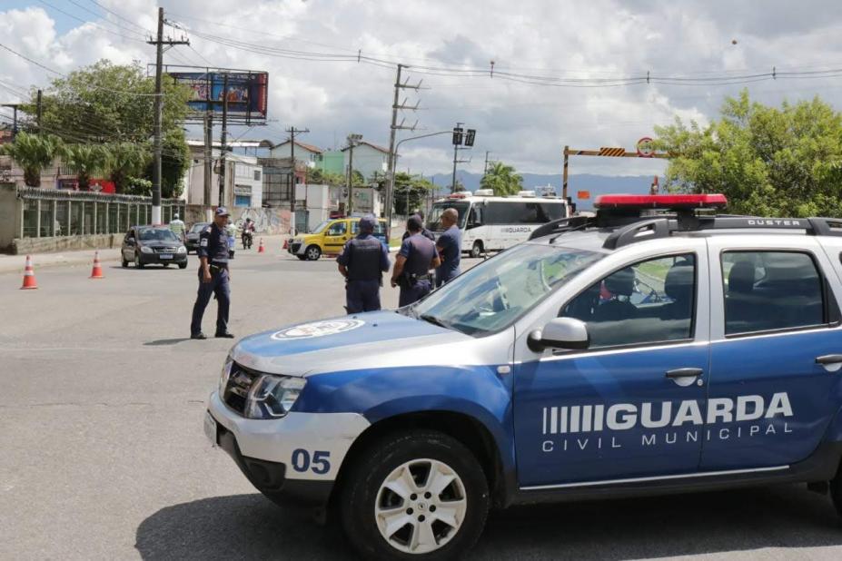 Viatura da guarda municipal está parada em via. Ao fundo, guardas e agentes da CET monitoram o trânsito