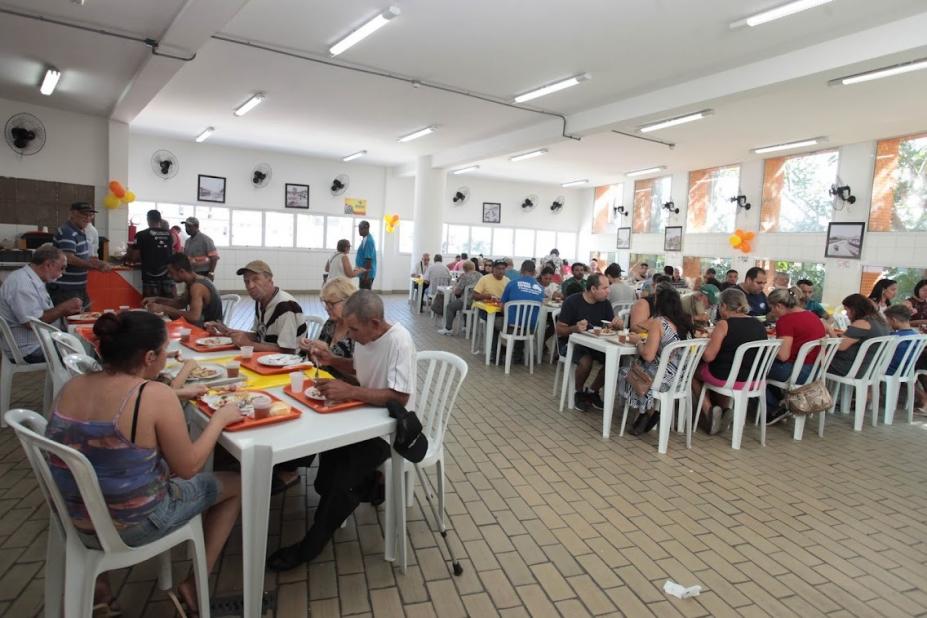 salão de restaurante bom prato com várias pessoas sentadas às mesas e comendo.  #paratodosverem