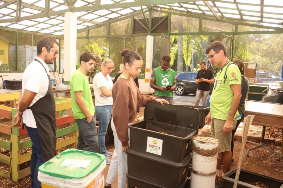 pessoas olhando mudas na semana da compostagem #paratodosverem