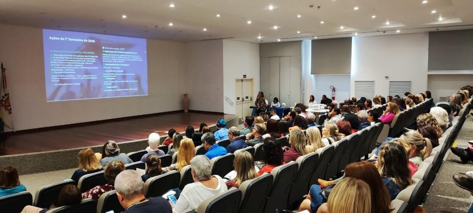 servidores sentados em auditório assistindo palestra. #paratodosverem