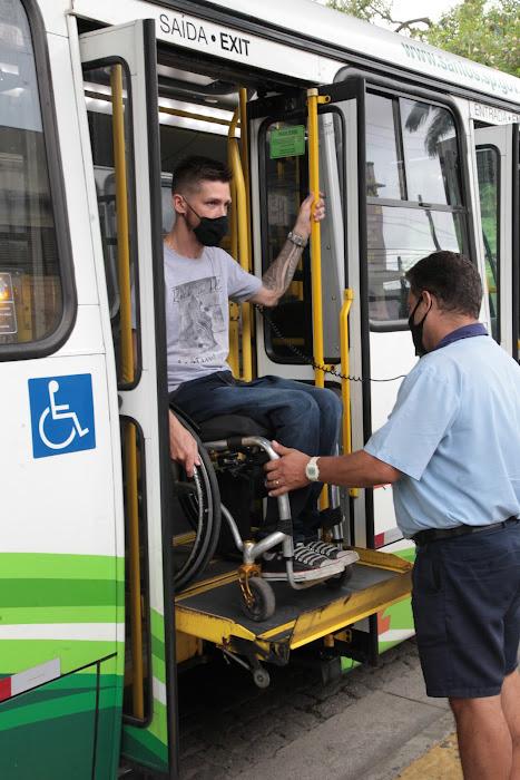 Cadeirante no alto de elevador operado por motorista de ônibus. #pratodosverem