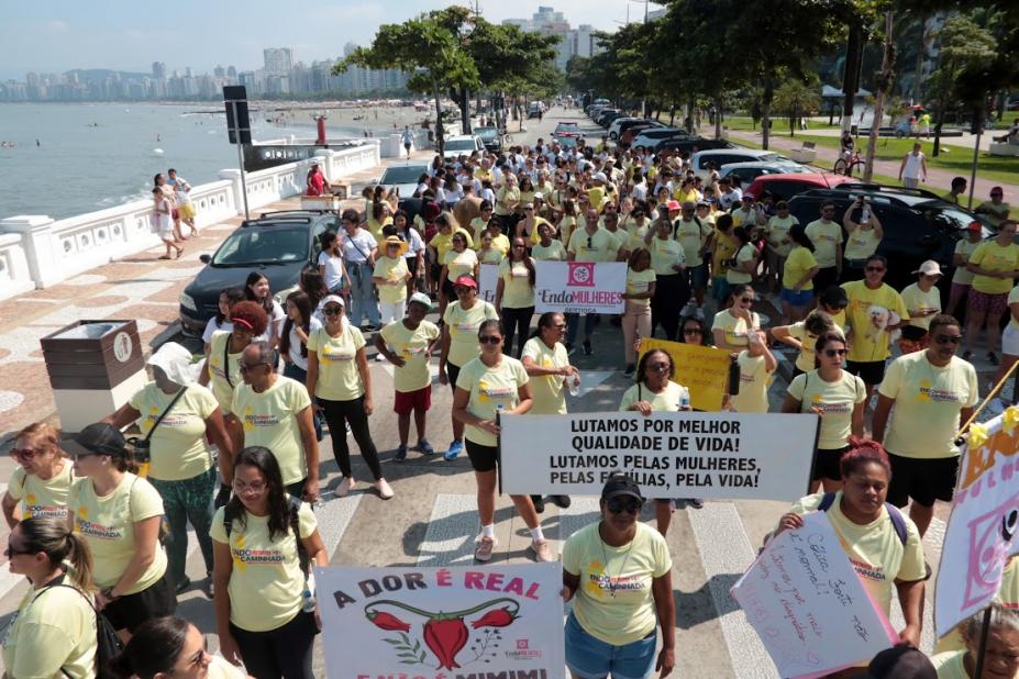 pessoas caminhando de amarelo na avenida da praia #paratodosverem 