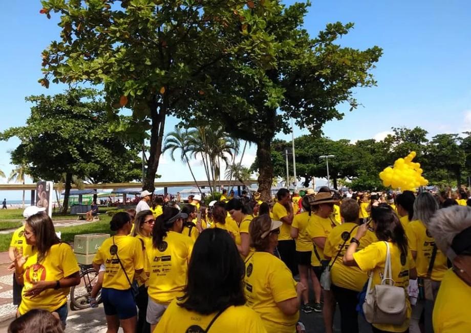 pessoas de amarelo em avenida na orla #paratodosverem