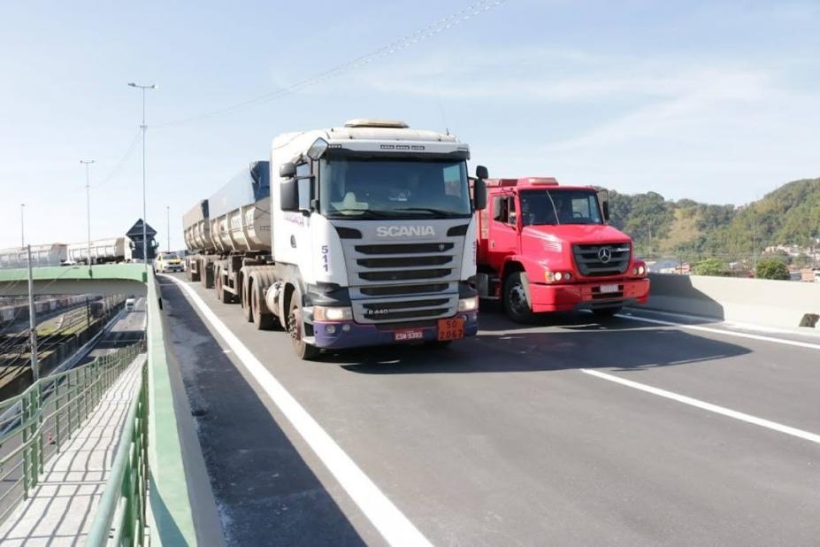 dois caminhões trafegam em pistas de viatudo. #paratodosverem