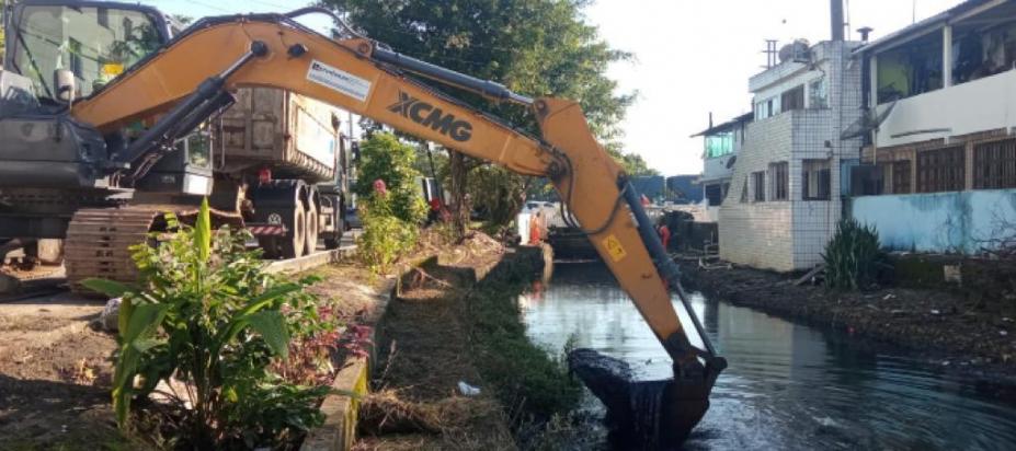 braço mecânico de caminhão estã removendo lama de canal. #paratodosverem