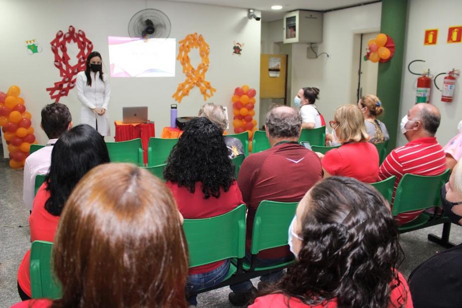palestrante e várias pessoas sentadas #paratodosverem