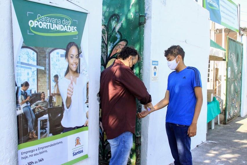 Jovem está tendo sua temperatura aferida na entrada do evento. #paratodosverem