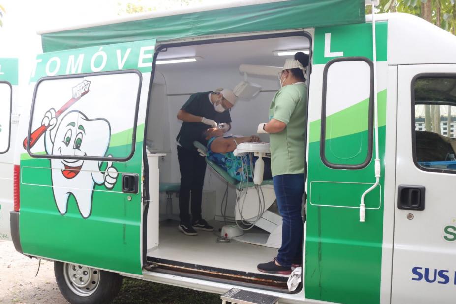 van com porta aberta e uma mulher na cadeira sendo atendida.#paratodosverem