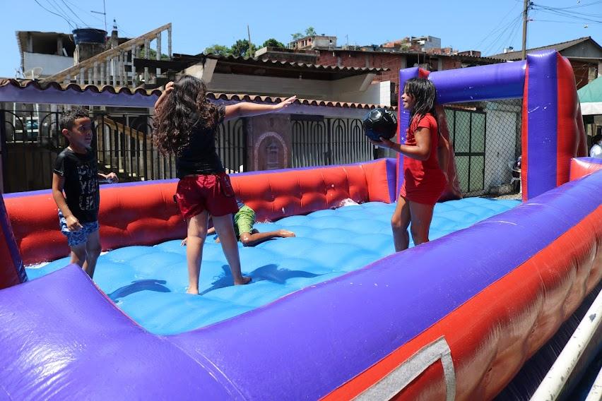 crianças pulam em brinquedo inflável. #paratodosverem