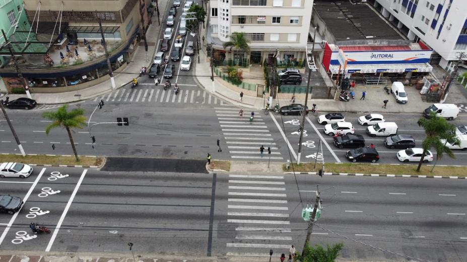 vista aérea de avenida com canteiro central recém-aberto. carros estão parados nos semáforos adjacentes. #paratodosverem