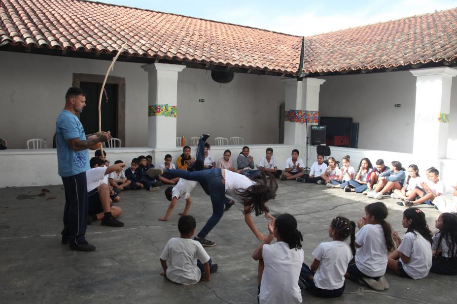 crianças jogam capoeira em quadra. #paratodosverem