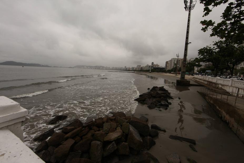 a ponta da praia em tom escuro, prenúncio de chuva. #paratodosverem 