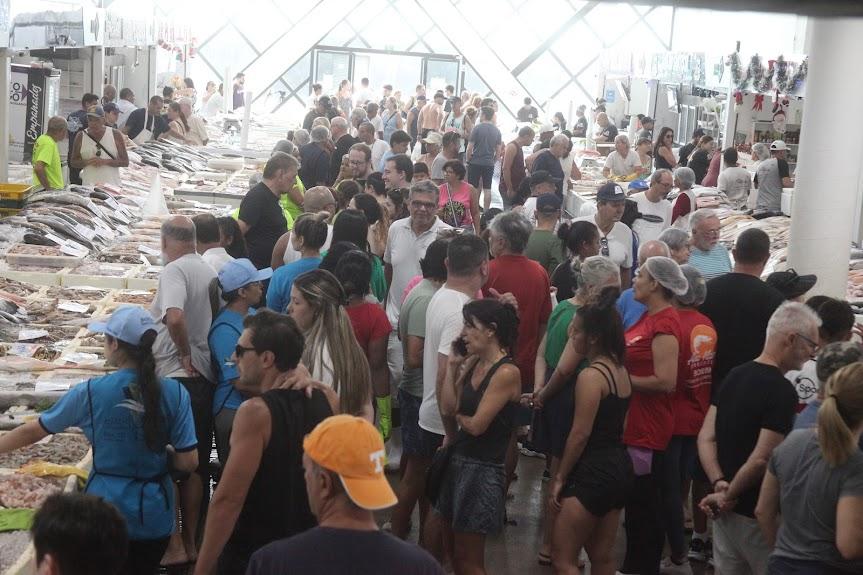 grande público circulando no mercado de peixes entre os boxes. #paratodosverem 