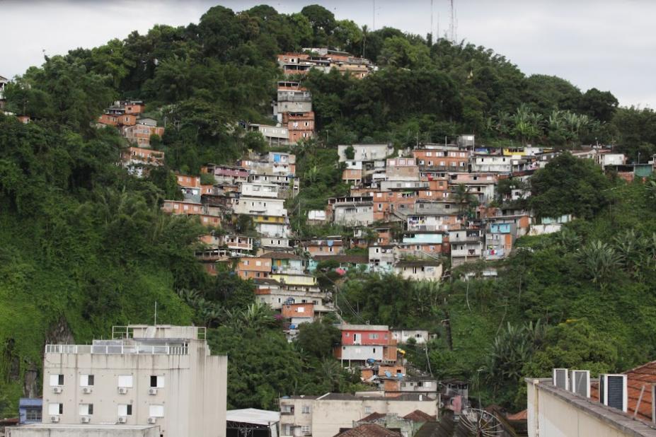 vista geral do monte serrat, com moradias à frent, cercadas por vegetação. #paratodosverem