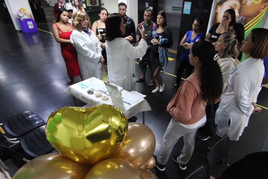 mulheres reunidas em saguão ouvem palestra. #paratodosverem