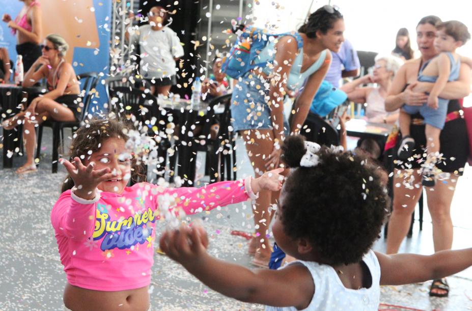 crianças se divertem com confetes na tenda