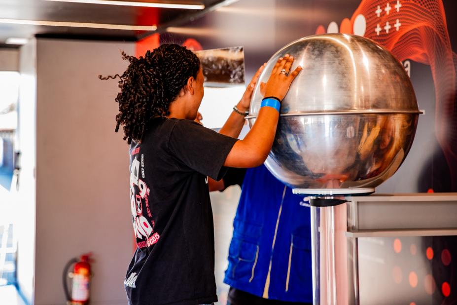 menina encosta em bola prateada #paratodosverem 