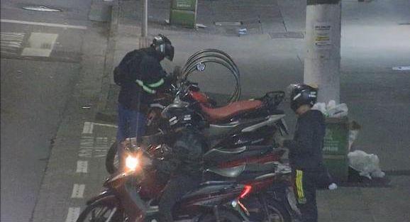 homem está mexendo em motocicleta estacionada ao lado de outras. Há outro homem ao lado. #paratodos