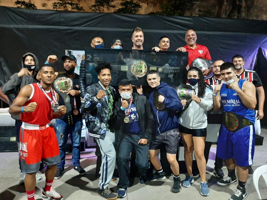 Equipe de boxe com atletas mostrando medalhas e cinturões #paratodosverem