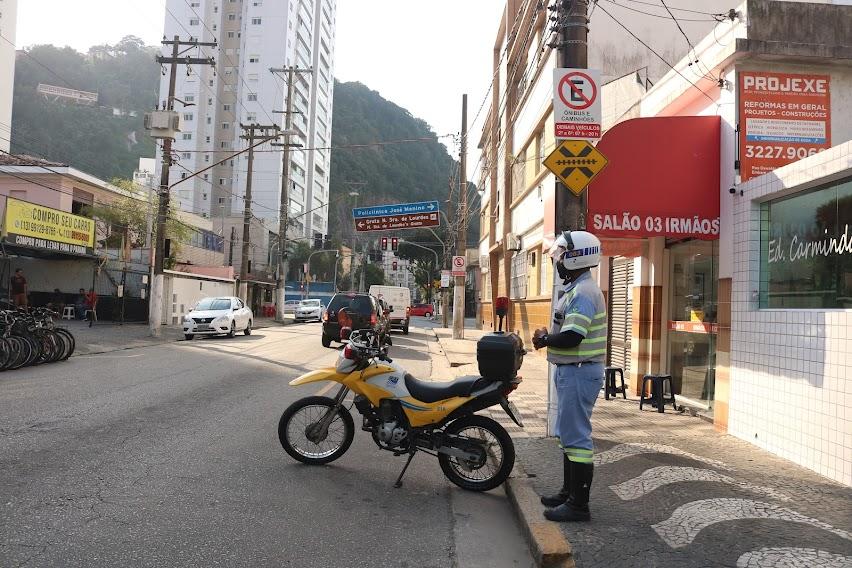 Agente da CET com a moto estacionada fiscaliza via. #paratodosverem