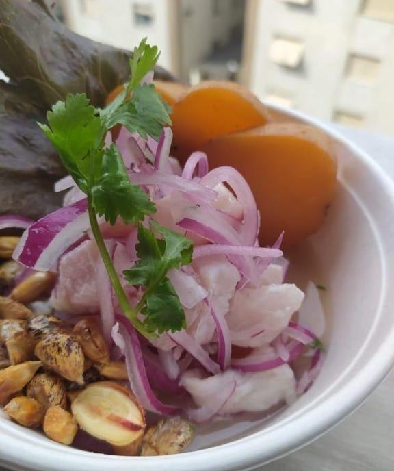 Prato de ceviche, com peixe, cebola, milho peruano e folhas de coentro. #Paratodosverem
