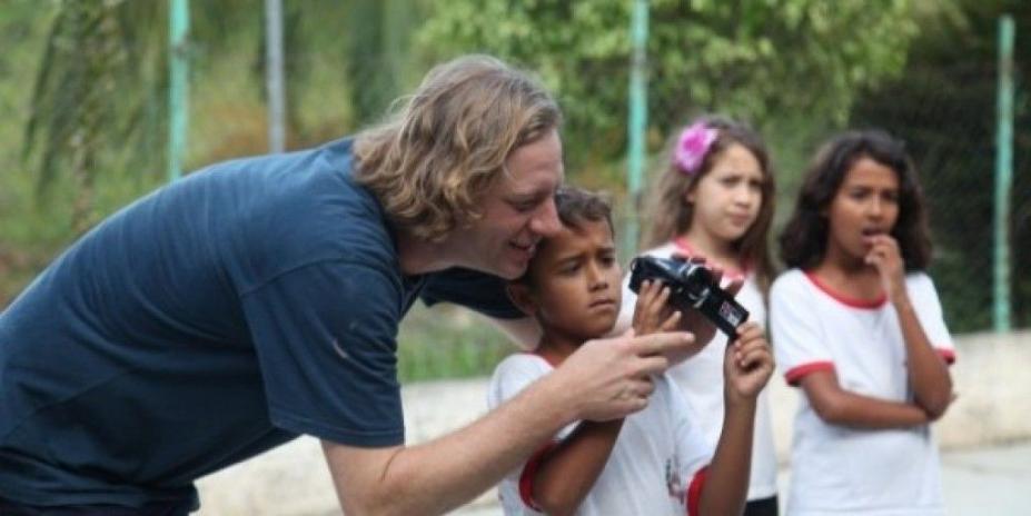 homem orienta menino que segura câmera de filmagem. #paratodosverem 