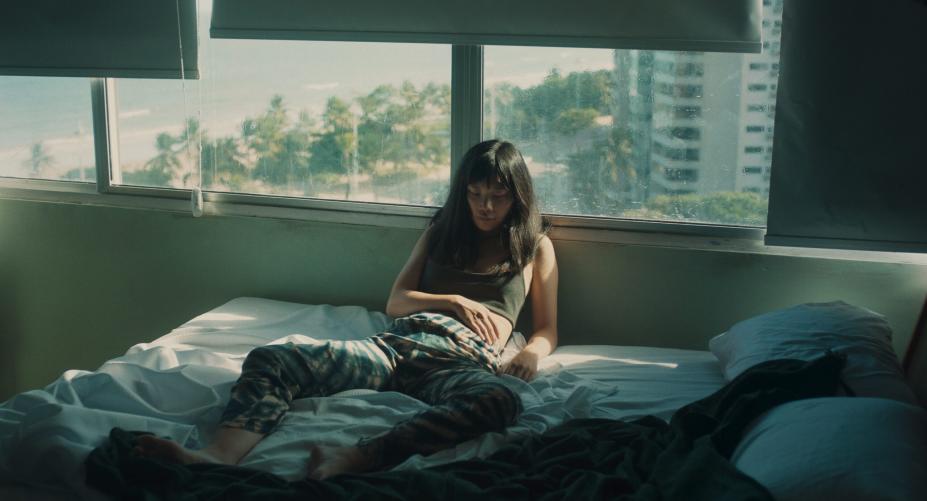 em cena de filme,  mulher está em cama, encostada em janela #paratodosverem