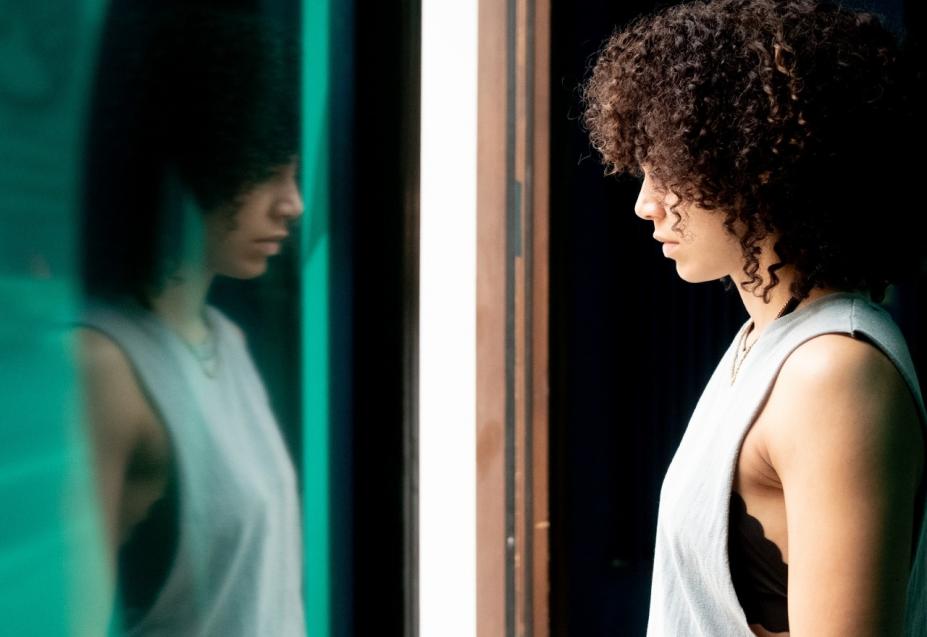 mulher negra se olha no espelho. #paratodosverem