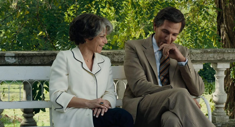 casal sentado lado a lado em área livre. #paratodosverem